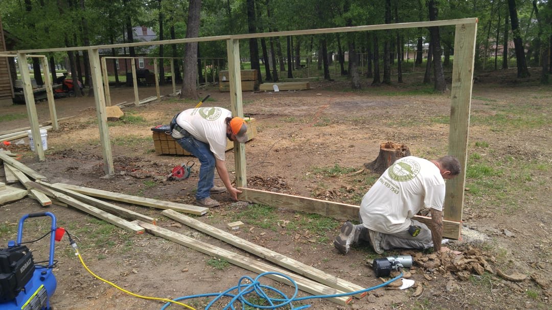 Crew building a wood fence on a job site