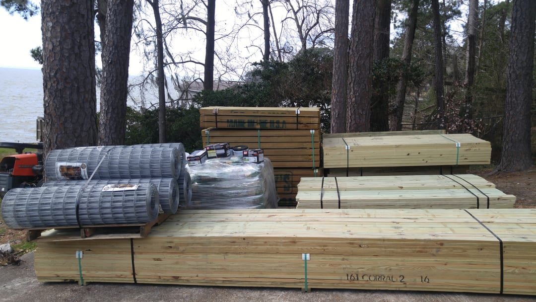 Posts and rails staged for a corral build