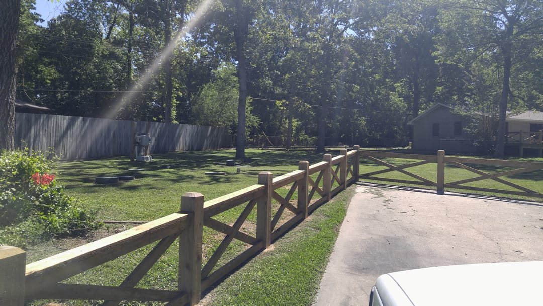 Cross buck fence with a gate at a driveway