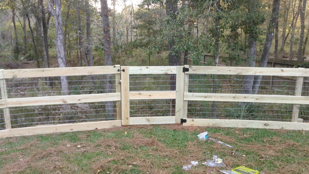 Wood rail fence with wire and a gate