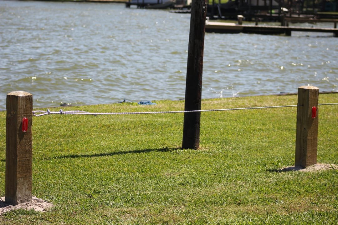 Post and rope fence along a lakefront walkway
