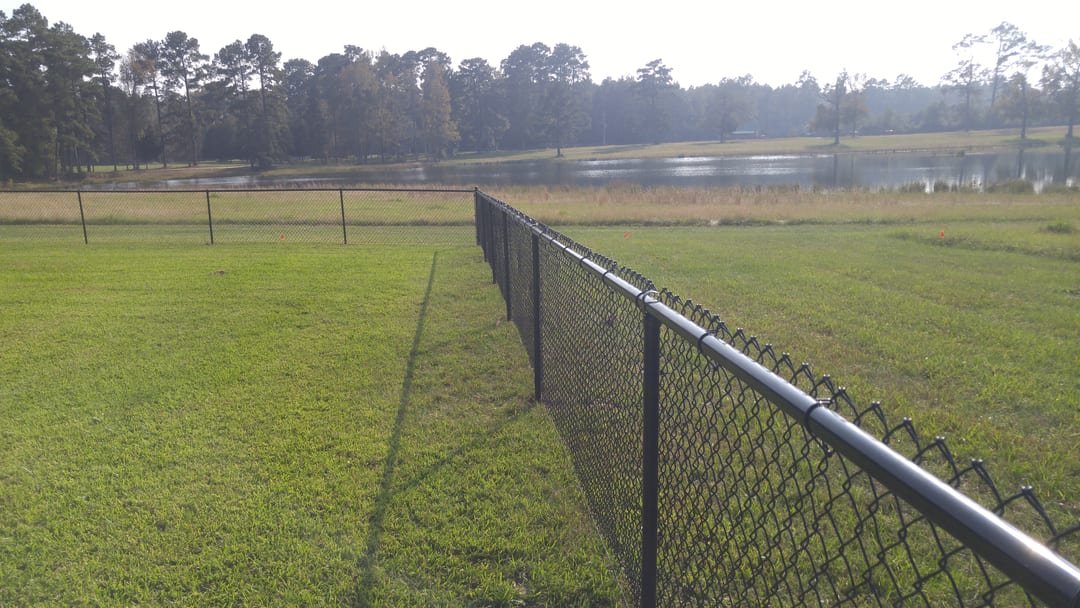 Black vinyl-coated chain link fence on a Lake Livingston waterfront lot