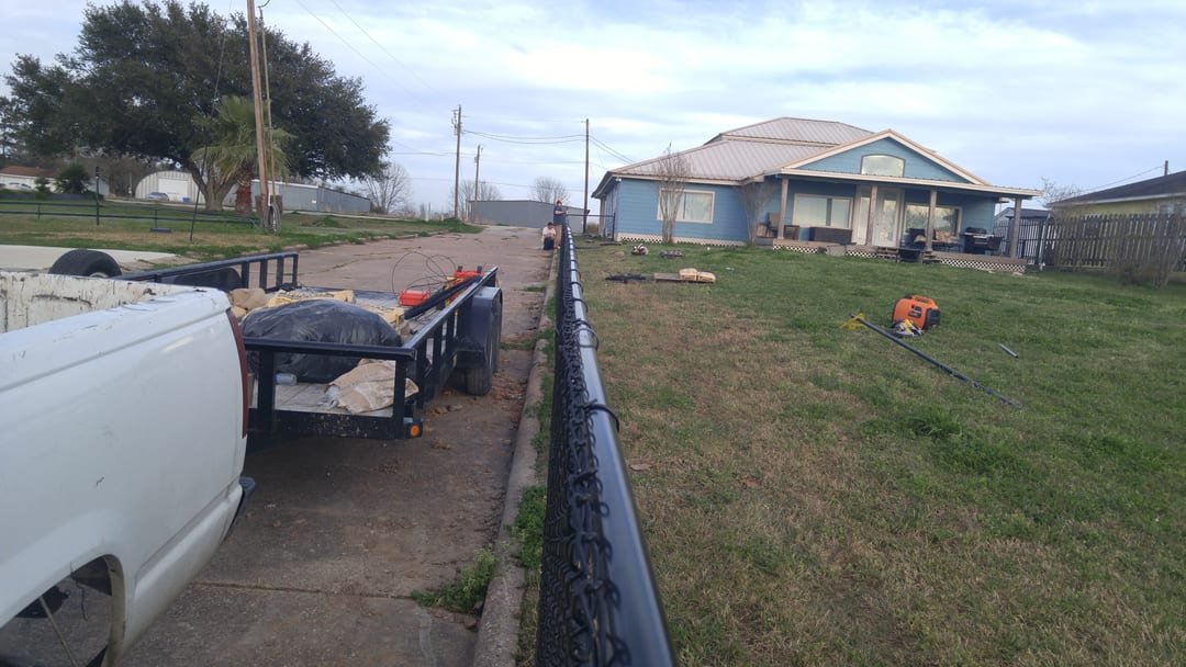 Chain link fence being re-stretched between posts
