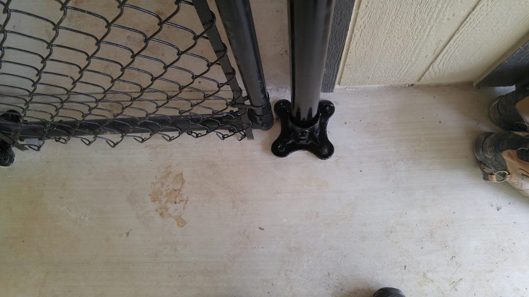 Chain link fence post set in a concrete footing