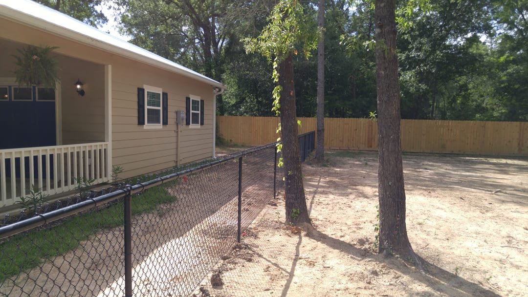 Chain link fence meeting a wood privacy fence at a property corner