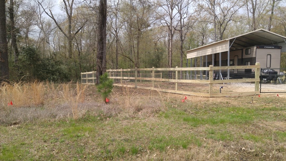 Black ornamental fence in front of a lake house with the water behind