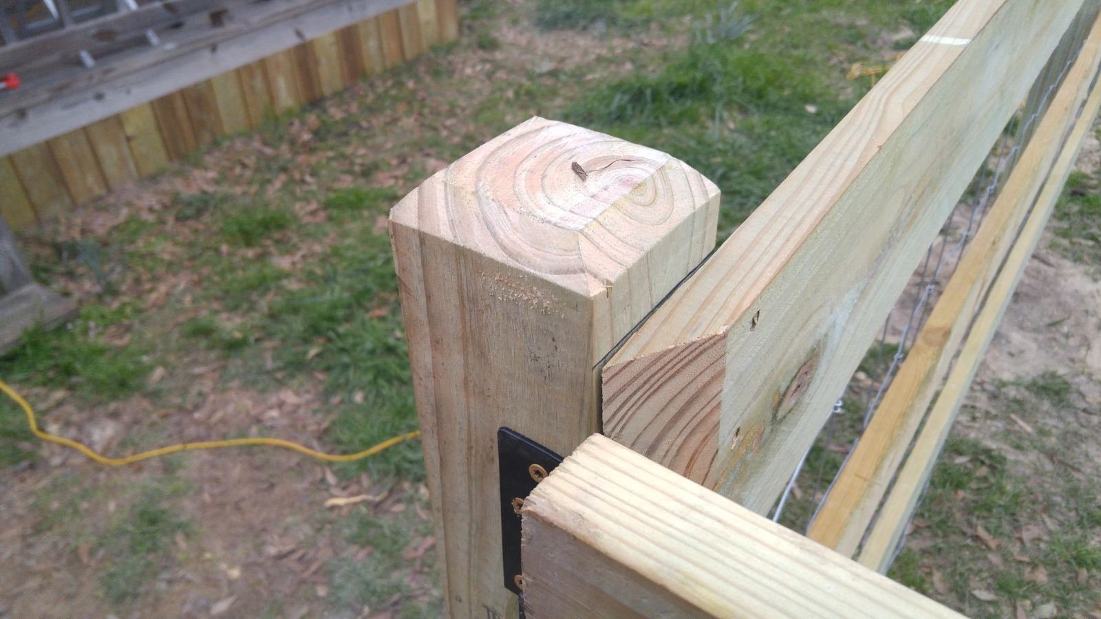 Corral fence with wood rails, wire mesh, and gate