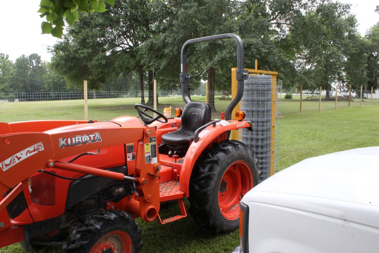 Tractor with wire roll unroller installing field fence