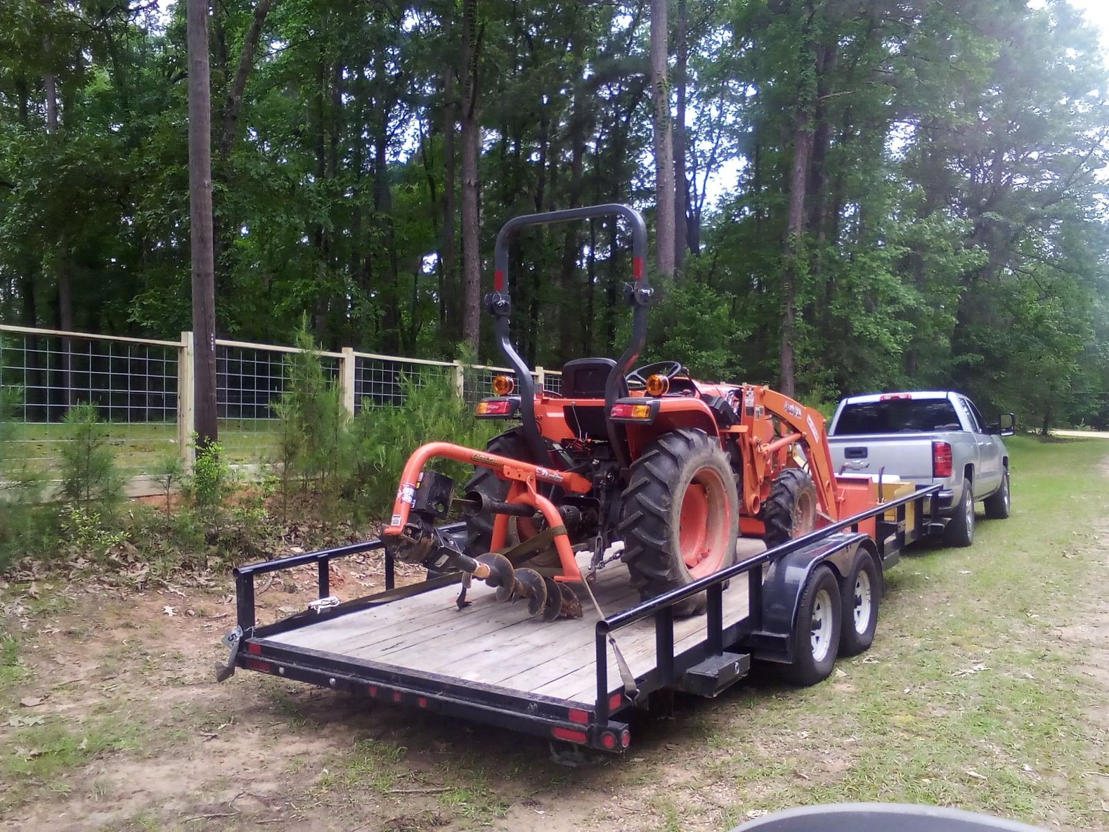 Field fence installation on ranch land with a tractor