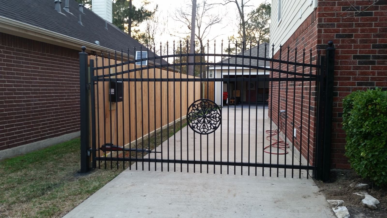 Automated ornamental driveway gate with solar-powered opener