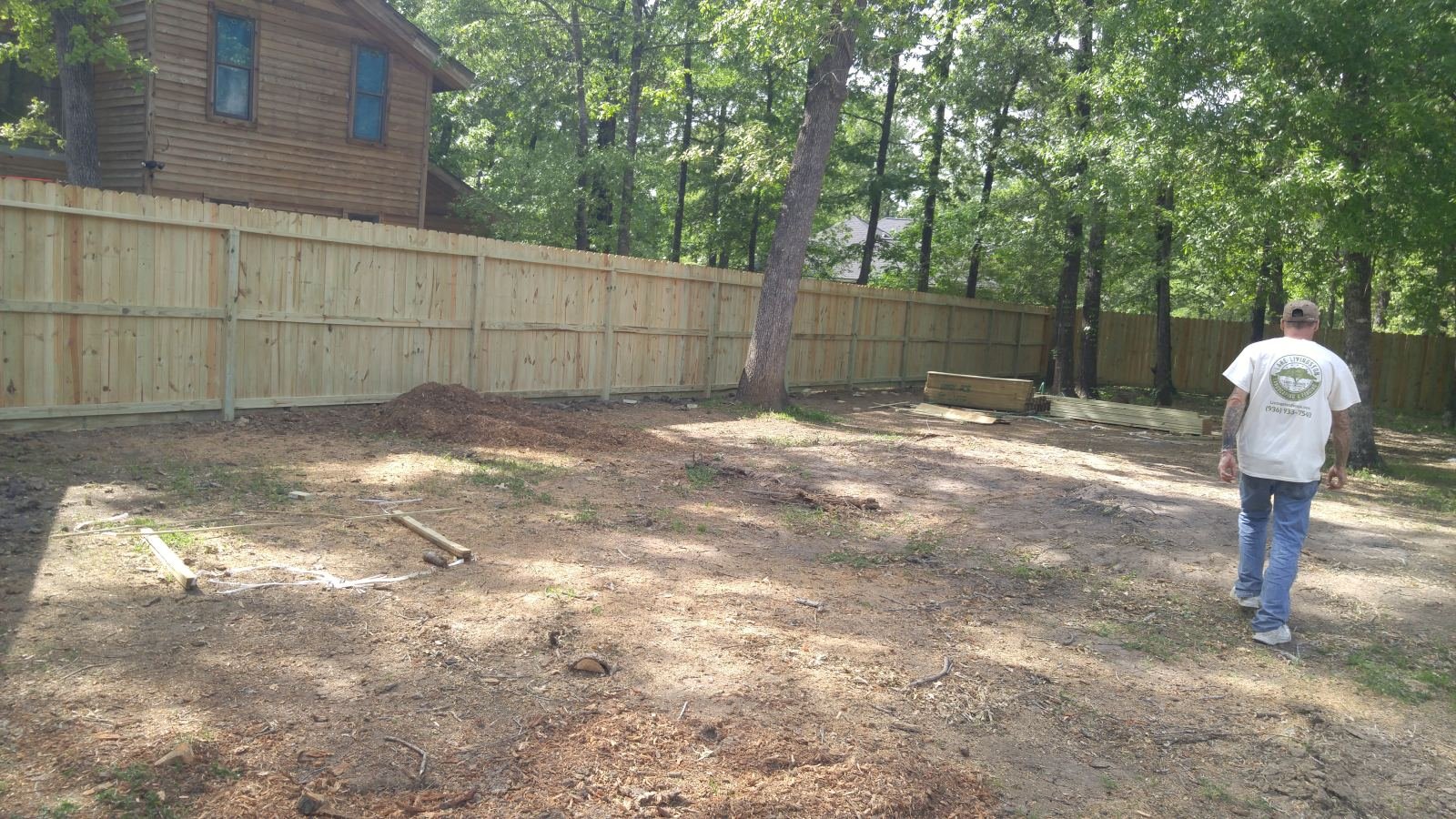 Crew member walking away from a freshly built privacy fence