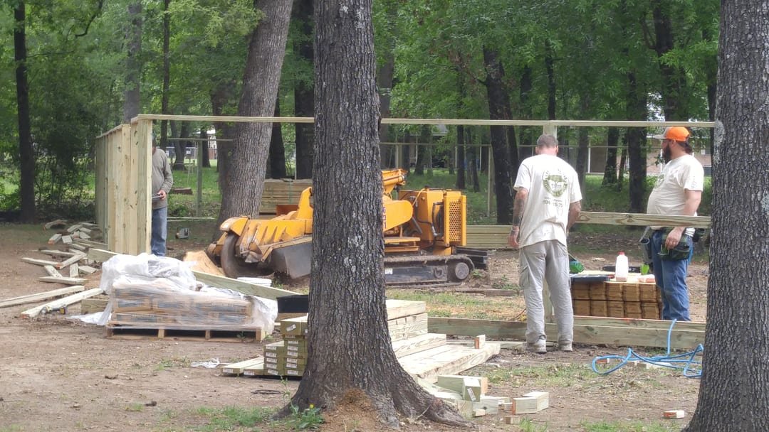 Privacy fence posts and three rails in place before pickets